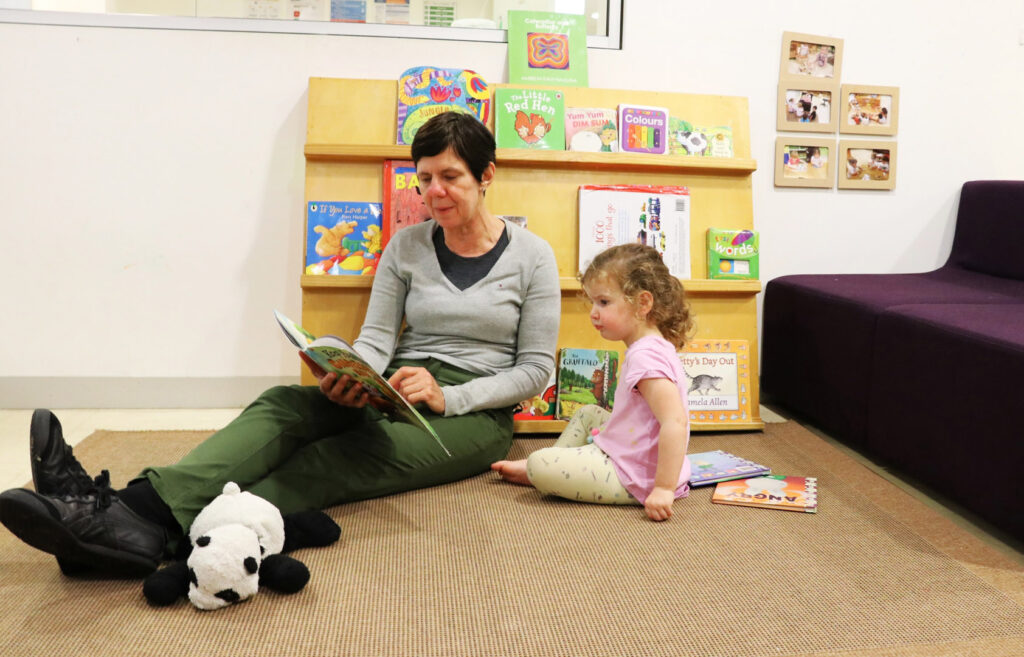 KU's The Tree House childcare educator reading to a child