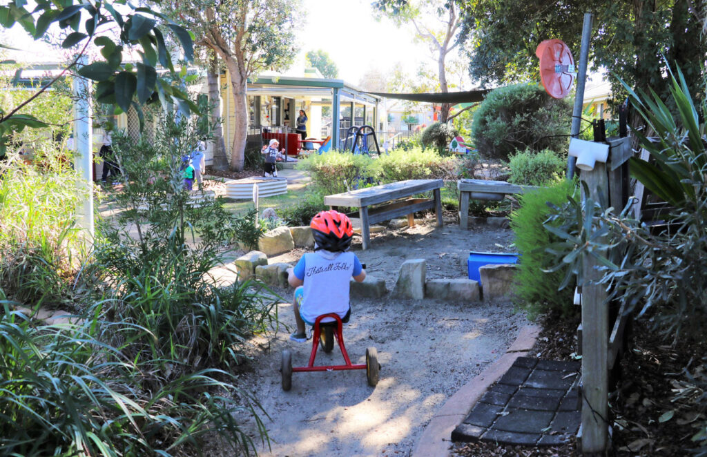 Child riding a tricycle at KU Peninsula childcare