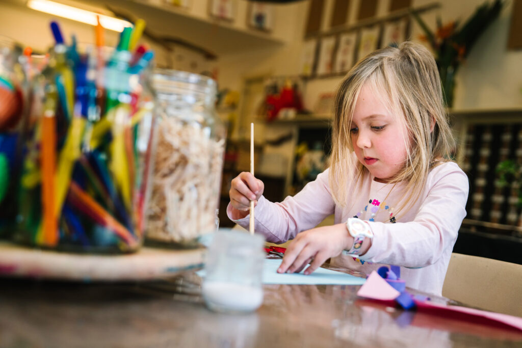 Child doing a painting at KU Tanilba Bay childcare