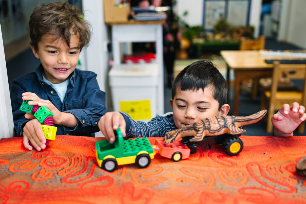 Children playing with trucks and dinosaurs at KU Tanilba Bay childcare