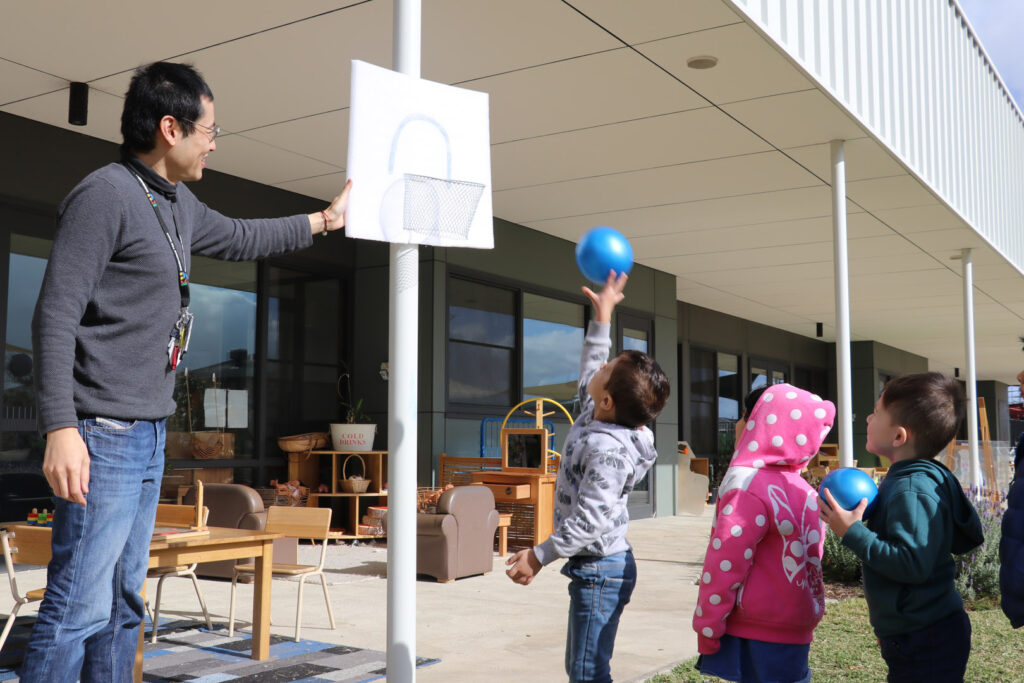 KU Dianella childcare educator supervising children playing basketball