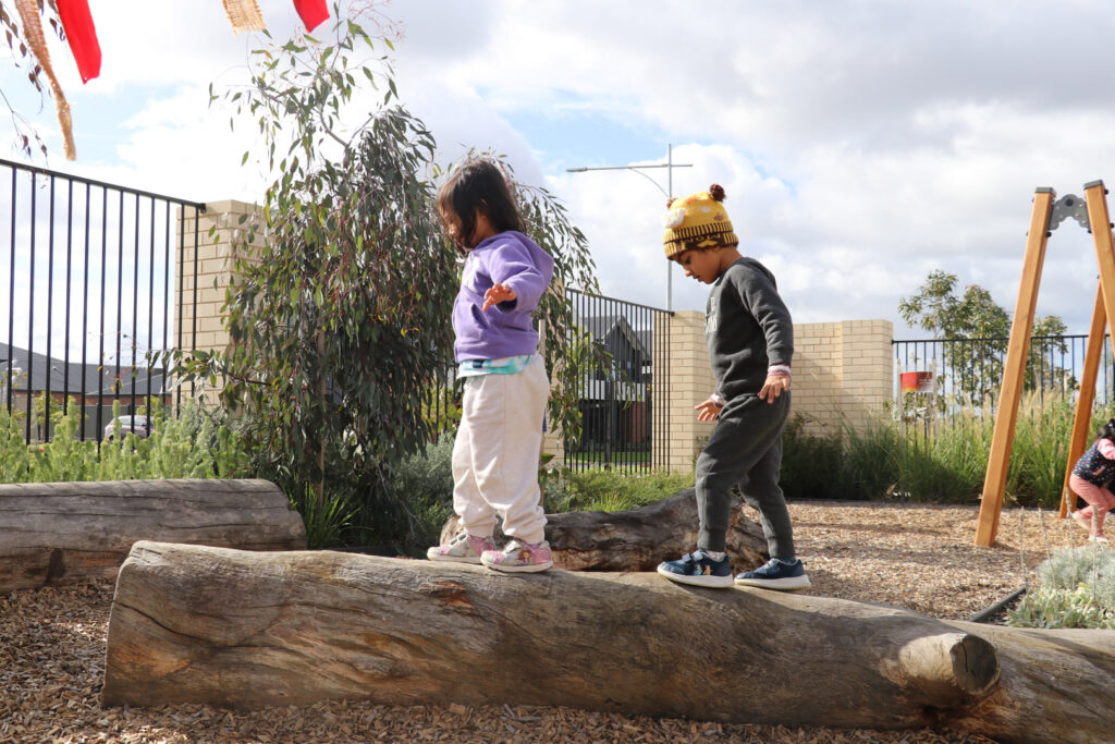 Children balancing on a log at KU Dianella childcare