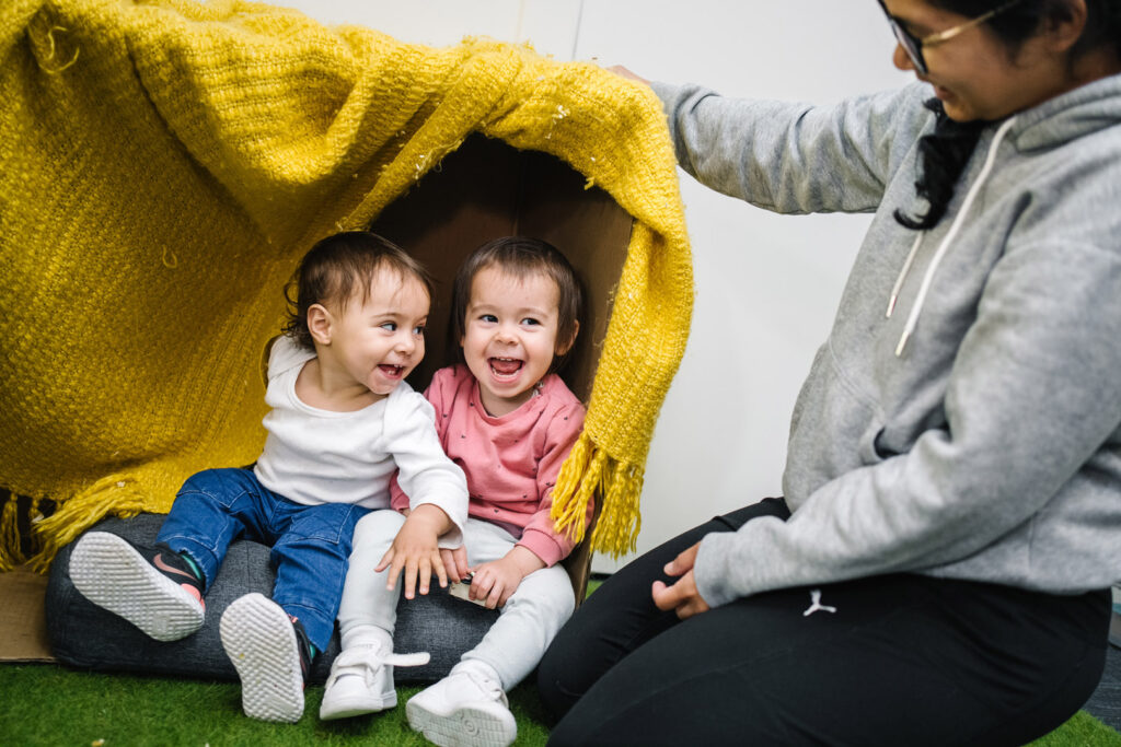 KU Ultimo childcare educator with children in a blanket fort