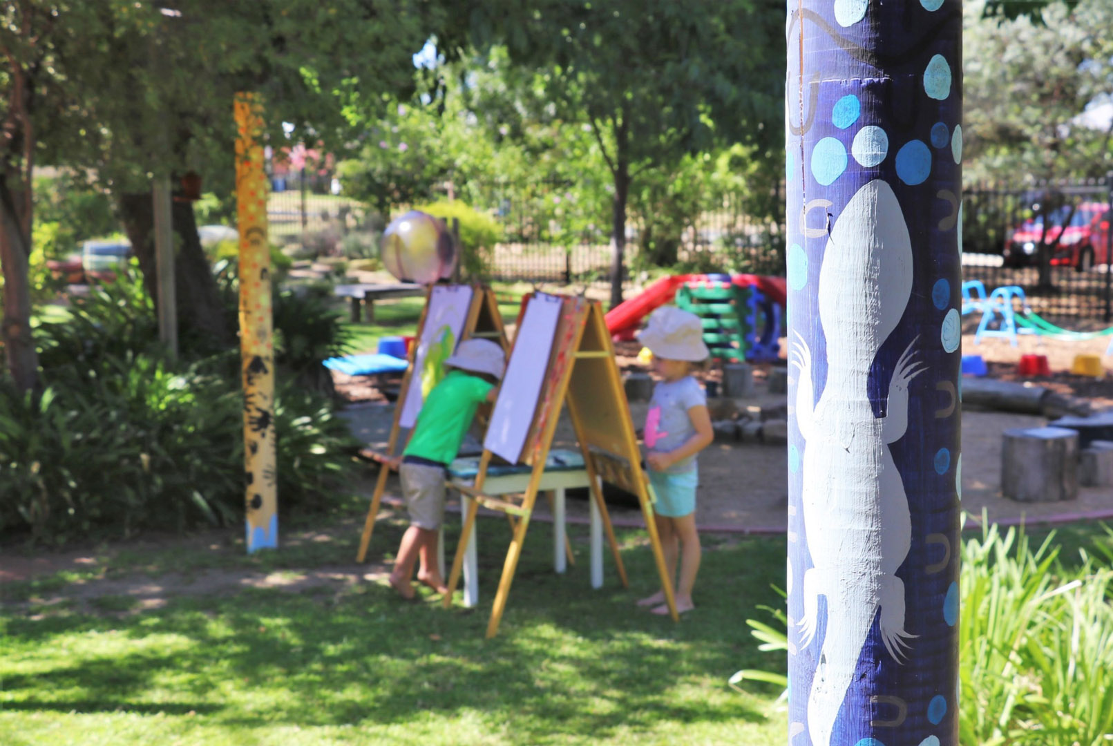 Children painting outdoors at KU Kingfisher childcare