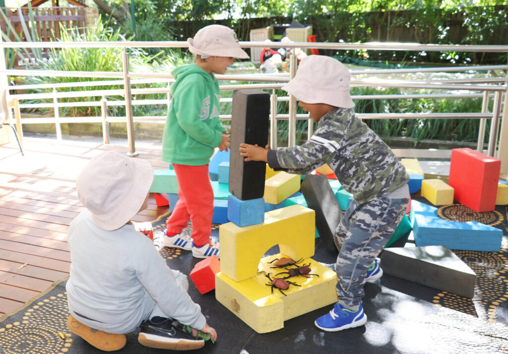 Children building blocks outdoors at KU Wahroonga childcare