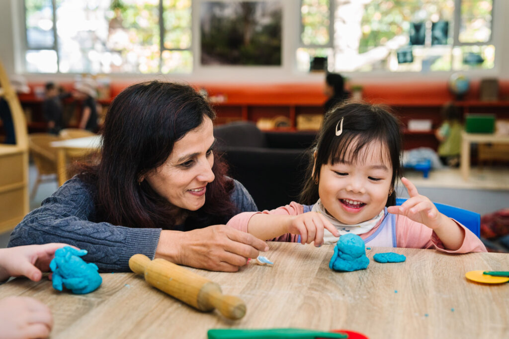 KU James Cahill childcare educator and a child sculpting with playdough