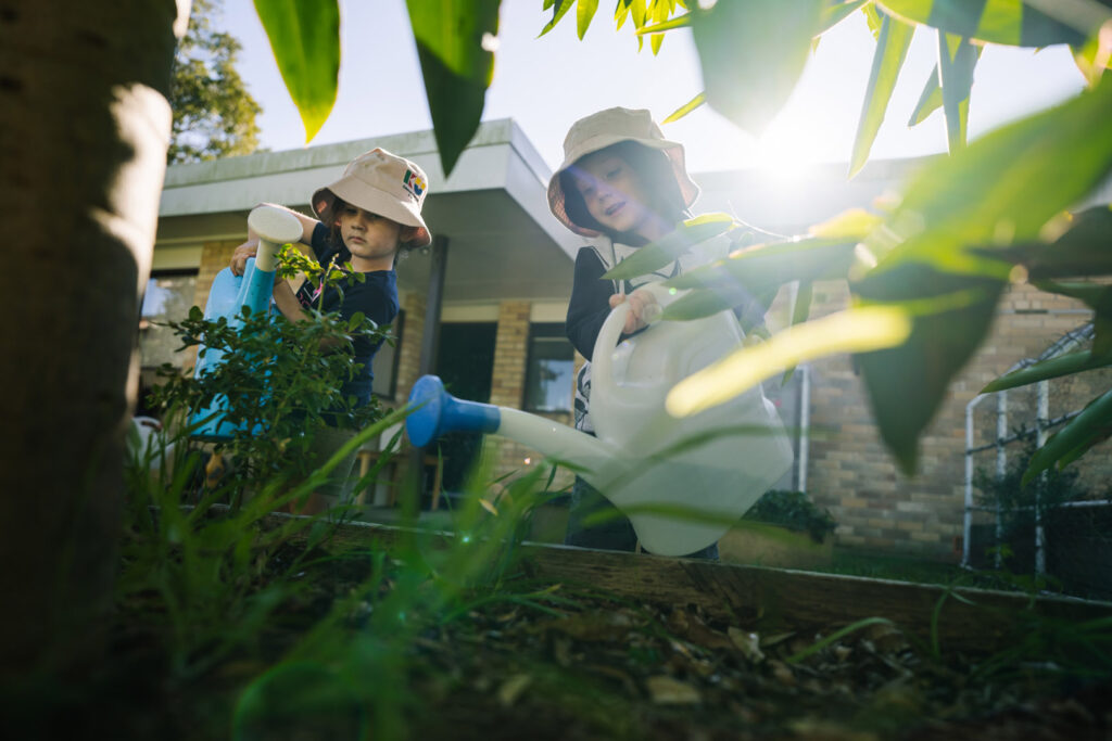 Children watering plants at KU Windale childcare