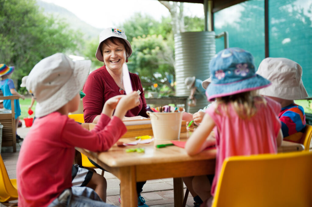 KU Wombarra childcare educator and some children doing arts and craft