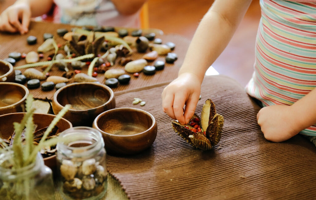 Children playing with seedpods and pebbles at KU Wombarra childcare